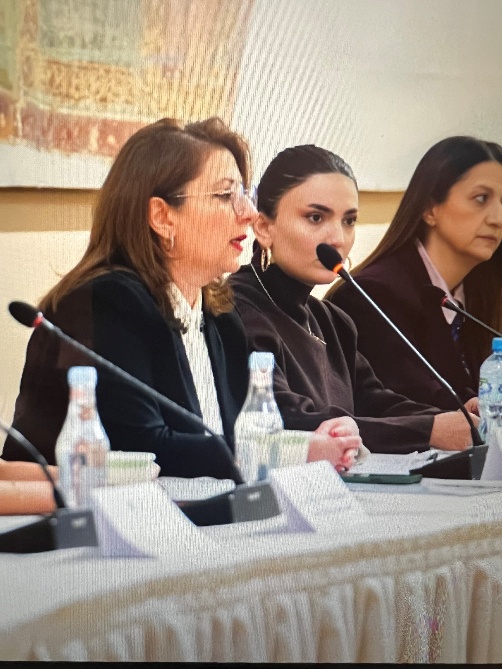 A group of women sitting at a table with microphones AI-generated content may be incorrect.