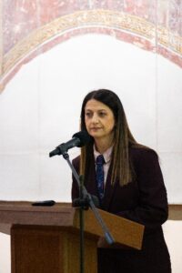 A person standing at a podium with a microphone AI-generated content may be incorrect.